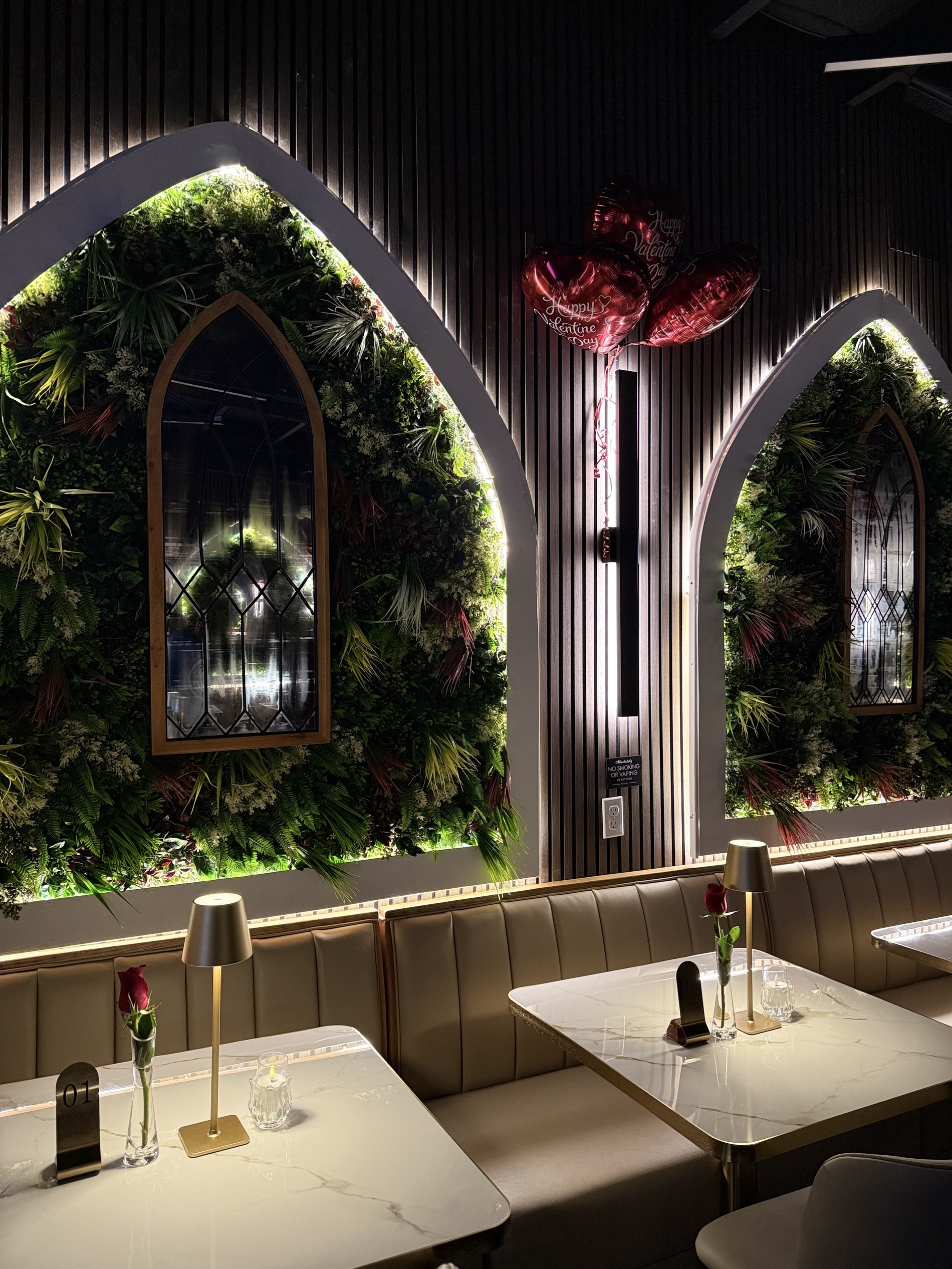 Marble tables set beneath the arched living walls